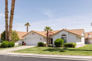 Mediterranean / spanish-style home featuring stucco siding, an attached garage, driveway, and a tile roof