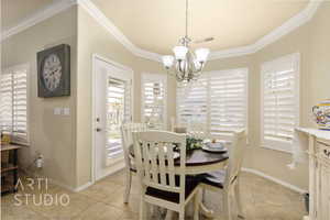 Dining area with a chandelier, crown molding, and light tile patterned floors