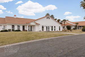 Mediterranean / spanish home featuring french doors, a tile roof, a front yard, and a chimney