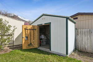 View of shed featuring a mountain view and fence
