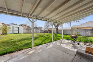 View of patio featuring a fenced backyard and shed
