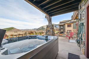 View of patio / terrace with a mountain view and a hot tub