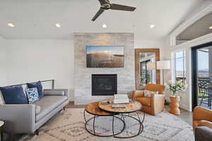 Living area with ceiling fan, a fireplace, recessed lighting, wood finished floors, and baseboards