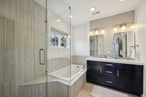Full bathroom featuring visible vents, recessed lighting, a whirlpool tub, a stall shower, and double vanity