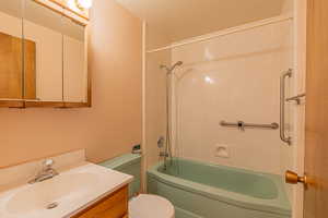 Full bathroom featuring toilet, vanity, and tub / shower combination