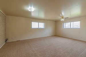 Spare room featuring light colored carpet and ceiling fan
