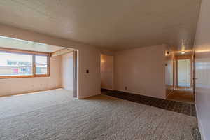 Carpeted empty room featuring a textured ceiling