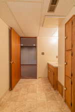 Bathroom with vanity, visible vents, and a drop ceiling