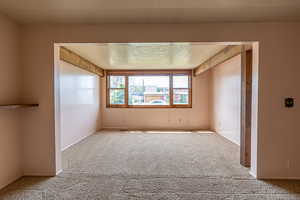 Unfurnished room featuring carpet and a textured ceiling