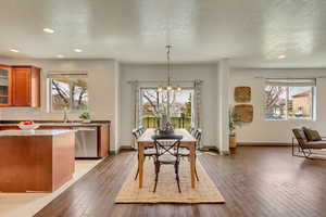 Dining room featuring light wood-style flooring, an inviting chandelier, and a healthy amount of sunlight