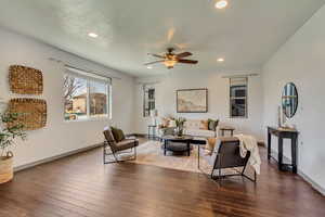 Living area featuring dark wood-type flooring, baseboards, a ceiling fan, and recessed lighting