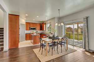 Dining space featuring a chandelier, stairs, recessed lighting, and wood finished floors