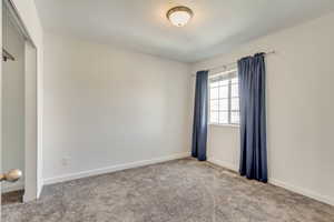 Unfurnished room with carpet, visible vents, and baseboards