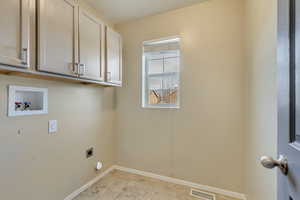 Laundry area with hookup for an electric dryer, baseboards, visible vents, hookup for a washing machine, and cabinet space
