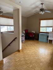 Interior space with baseboards, lofted ceiling, an upstairs landing, and a wealth of natural light