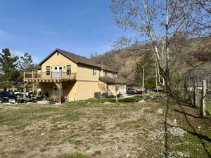 View of yard with central AC and a deck