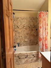 Bathroom with tile patterned floors, vanity, and tiled shower / bath