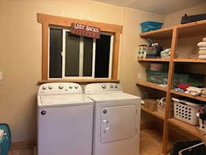 Washroom with independent washer and dryer, laundry area, and baseboards