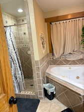 Full bathroom with tile patterned flooring, a jetted tub, and a stall shower