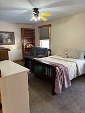 Carpeted bedroom featuring a ceiling fan