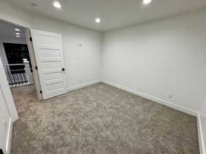 Carpeted empty room featuring baseboards and recessed lighting