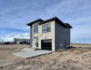 View of home's exterior with board and batten siding, an attached garage, stone siding, and concrete driveway