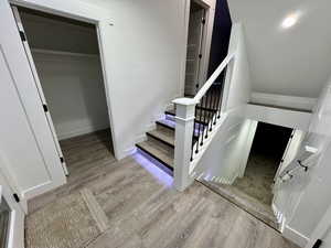 Stairway with visible vents, baseboards, and wood finished floors