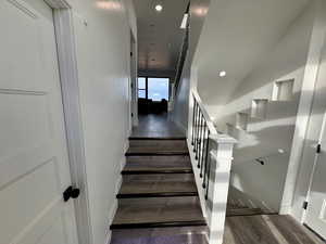 Staircase featuring wood finished floors, baseboards, and recessed lighting