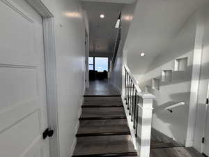 Stairs with recessed lighting, baseboards, and wood finished floors