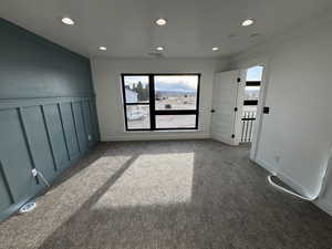 Unfurnished room with a wealth of natural light, recessed lighting, and dark carpet