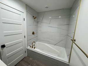 Bathroom featuring  shower combination and wood finished floors