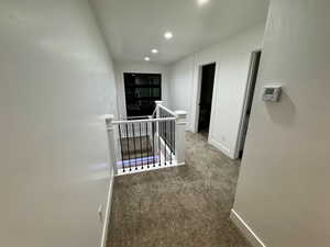 Corridor featuring recessed lighting, an upstairs landing, baseboards, and carpet floors