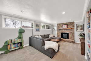 Living area featuring a textured ceiling, carpet flooring, baseboards, and ornamental molding