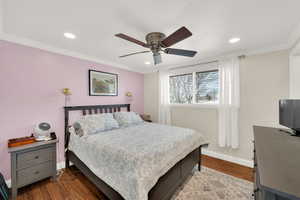 Bedroom featuring baseboards, crown molding, and wood finished floors