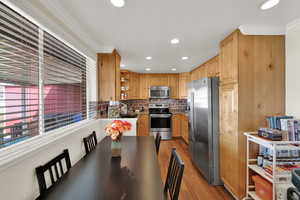 Dining room with crown molding, light wood finished floors, and recessed lighting