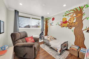 Bedroom featuring recessed lighting, baseboards, crown molding, and wood finished floors