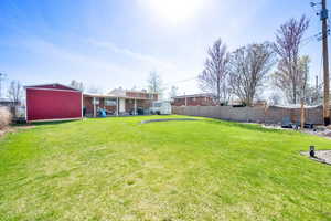 View of yard featuring a fenced backyard, a storage shed, an outdoor structure, and a patio area
