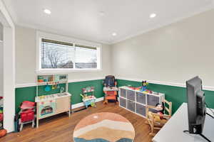 Recreation room featuring crown molding, baseboards, recessed lighting, and wood finished floors