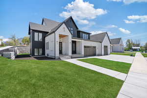 Modern farmhouse featuring a garage, concrete driveway, roof with shingles, and a front yard