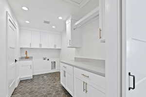 Laundry area with a sink, hookup for a washing machine, recessed lighting, hookup for an electric dryer, and visible vents