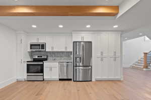 Kitchen featuring appliances with stainless steel finishes, baseboards, and white cabinets