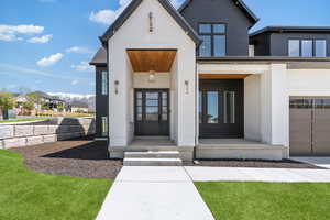 Doorway to property with brick siding and covered porch