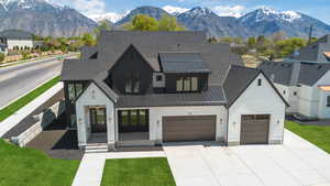 View of front of house with a garage, a mountain view, concrete driveway, a standing seam roof, and metal roof