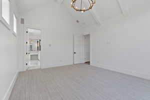 Interior space featuring high vaulted ceiling, baseboards, beamed ceiling, and a chandelier