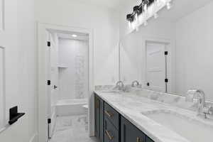 Full bath featuring double vanity, a sink, marble finish floor, and toilet