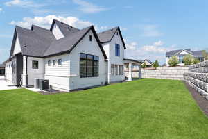 Back of house featuring a lawn, a shingled roof, a fenced backyard, and central AC unit