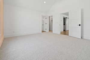 Unfurnished bedroom featuring baseboards, high vaulted ceiling, recessed lighting, a spacious closet, and carpet flooring