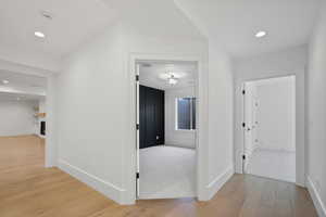 Hall featuring baseboards, recessed lighting, and light wood-style flooring