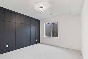 Unfurnished bedroom featuring baseboards and light carpet