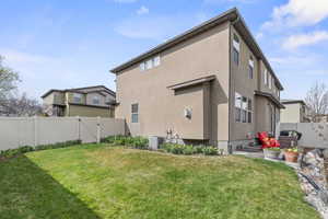Back of house with a yard, a fenced backyard, a gate, and central air condition unit